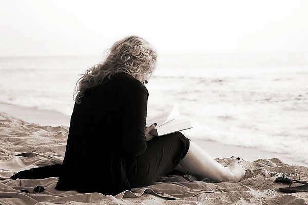 Жена чита книга покрај море