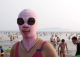 Кинезите одат на плажа со маски за да се заштитат од сонцето